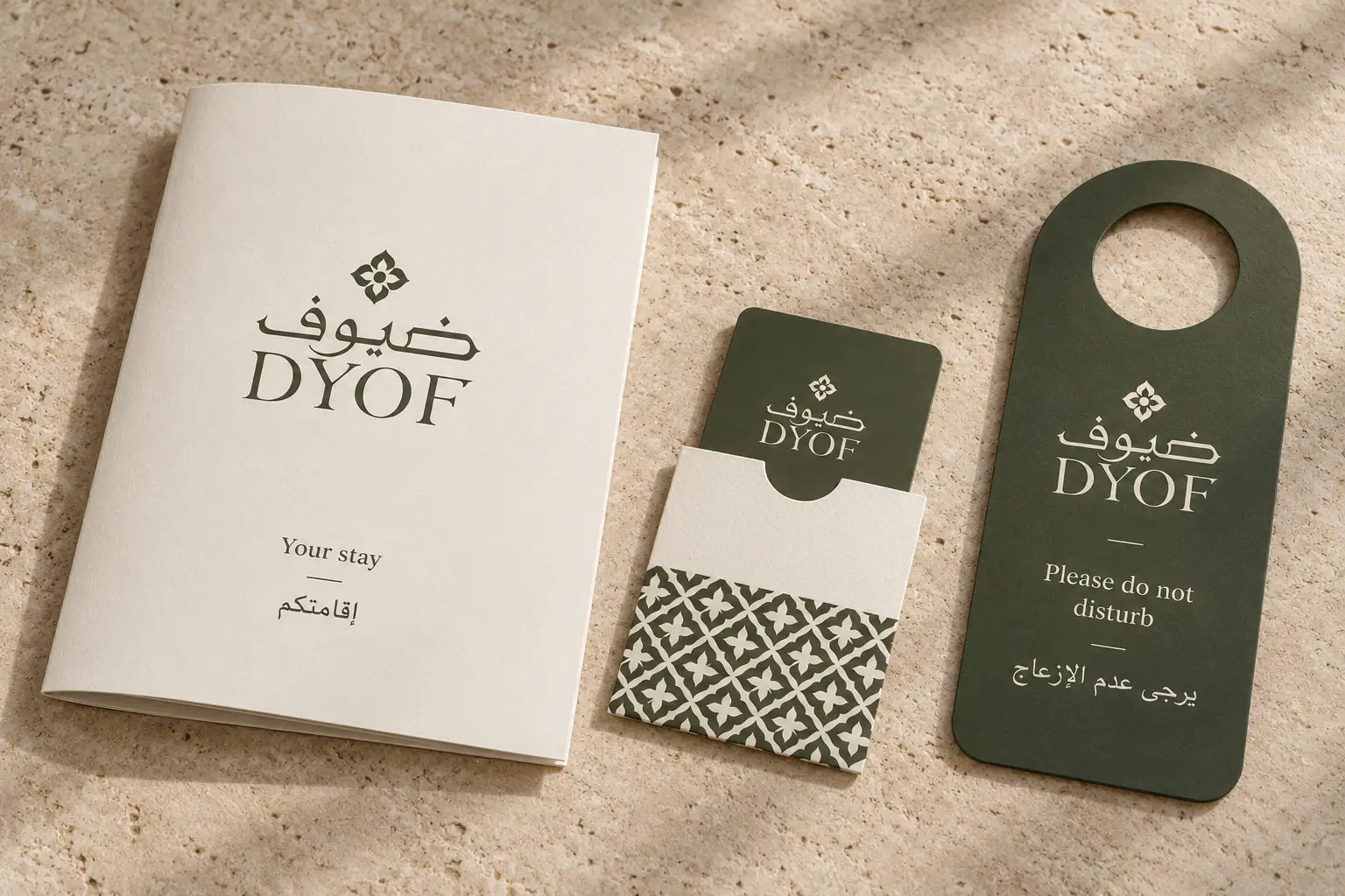 A DYOF welcome booklet, key card and door hanger on a travertine surface